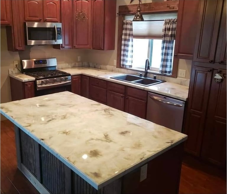 Modern kitchen with red wood cabinets, stainless steel appliances, and a large marble-topped island with blue base