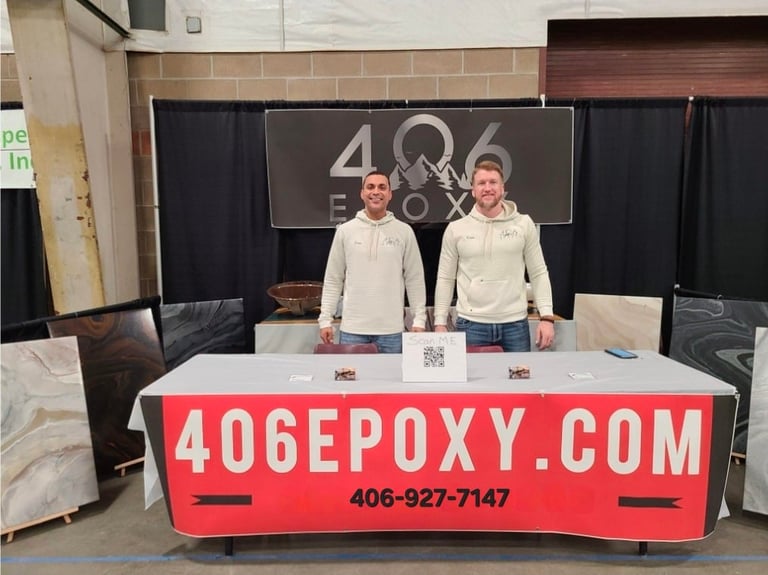 Two men standing behind a red and white trade show booth with 406epoxy.com branding and signage