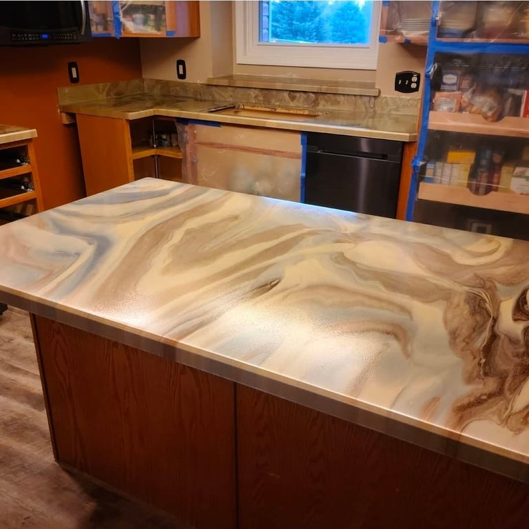 Modern kitchen with large marble-patterned countertop island, orange cabinetry, and stainless steel appliances visible in background