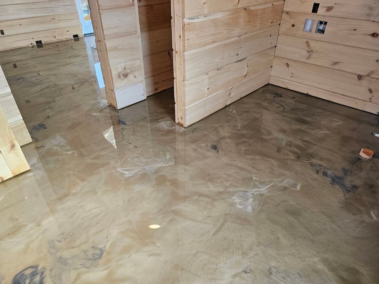 Interior of wooden structure with wet concrete floor and water pooling in areas