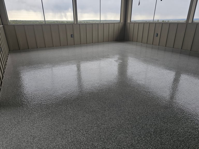 Empty high-rise interior with polished concrete floor, metal wall panels, and floor-to-ceiling windows overlooking a cityscape