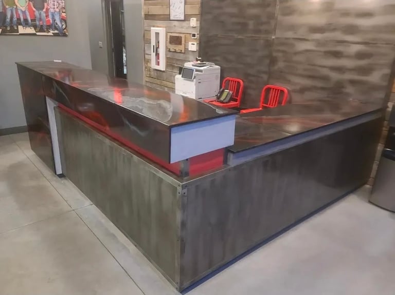 Modern reception desk with red and metallic finishes, red chairs, and office supplies in a contemporary interior