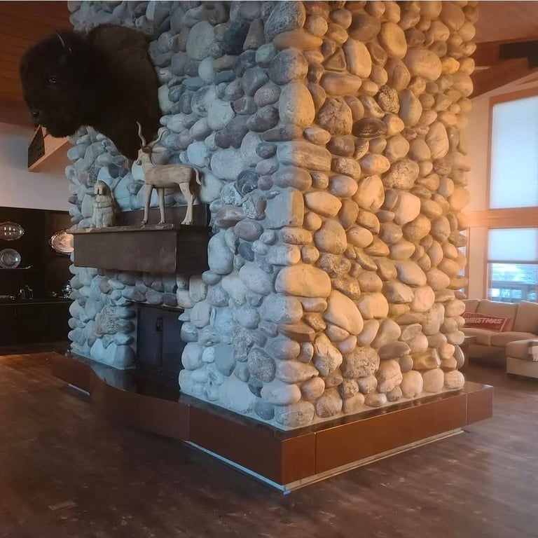 Modern sculptural column with blue and tan textured spheres inside a gallery space with large windows